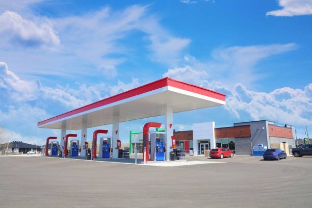 Modern Service Station with convenience store and a few cars, in a Sunny Day